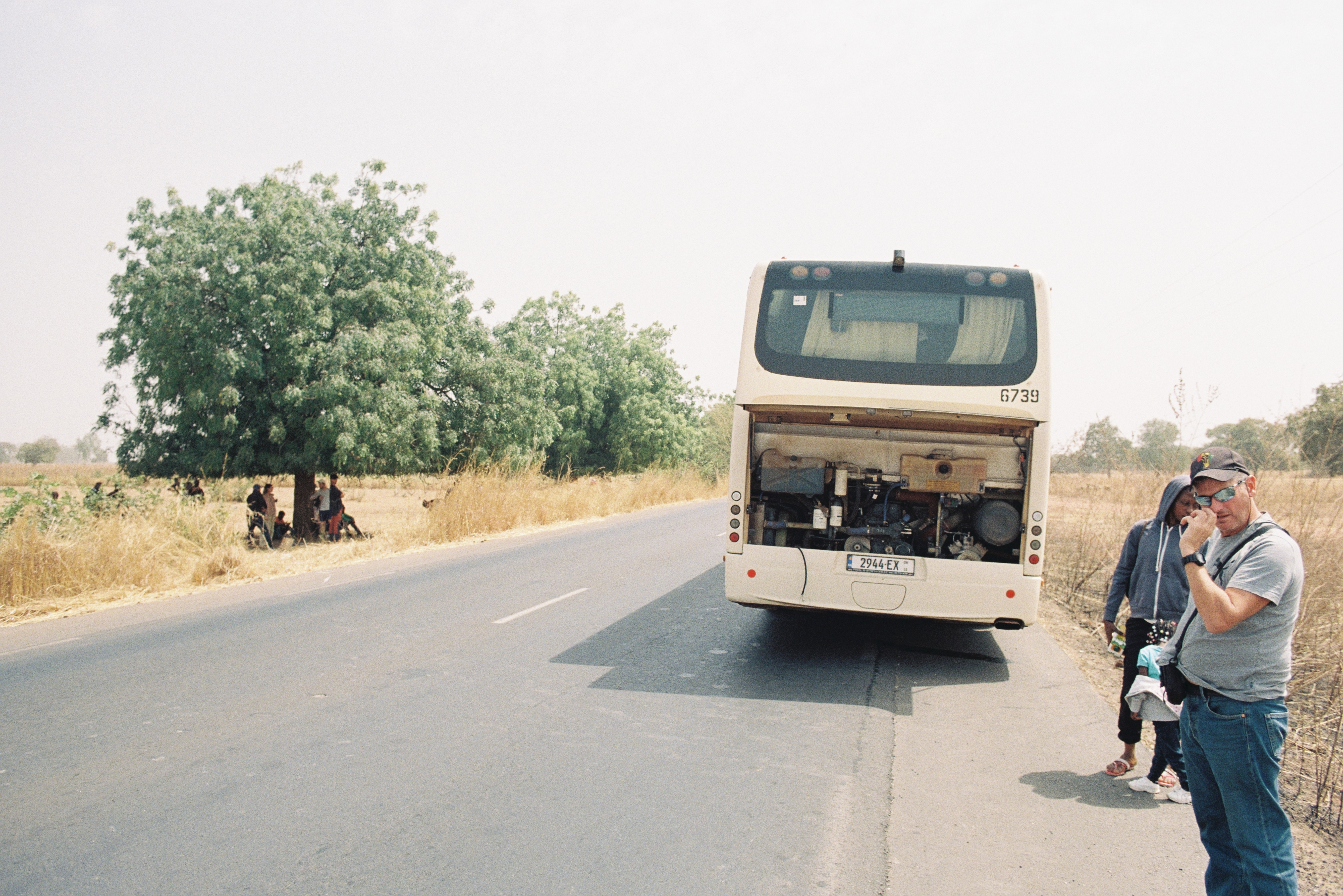 Stranded bus and travelers sheltering under a tree between Kaolack and The Gambia