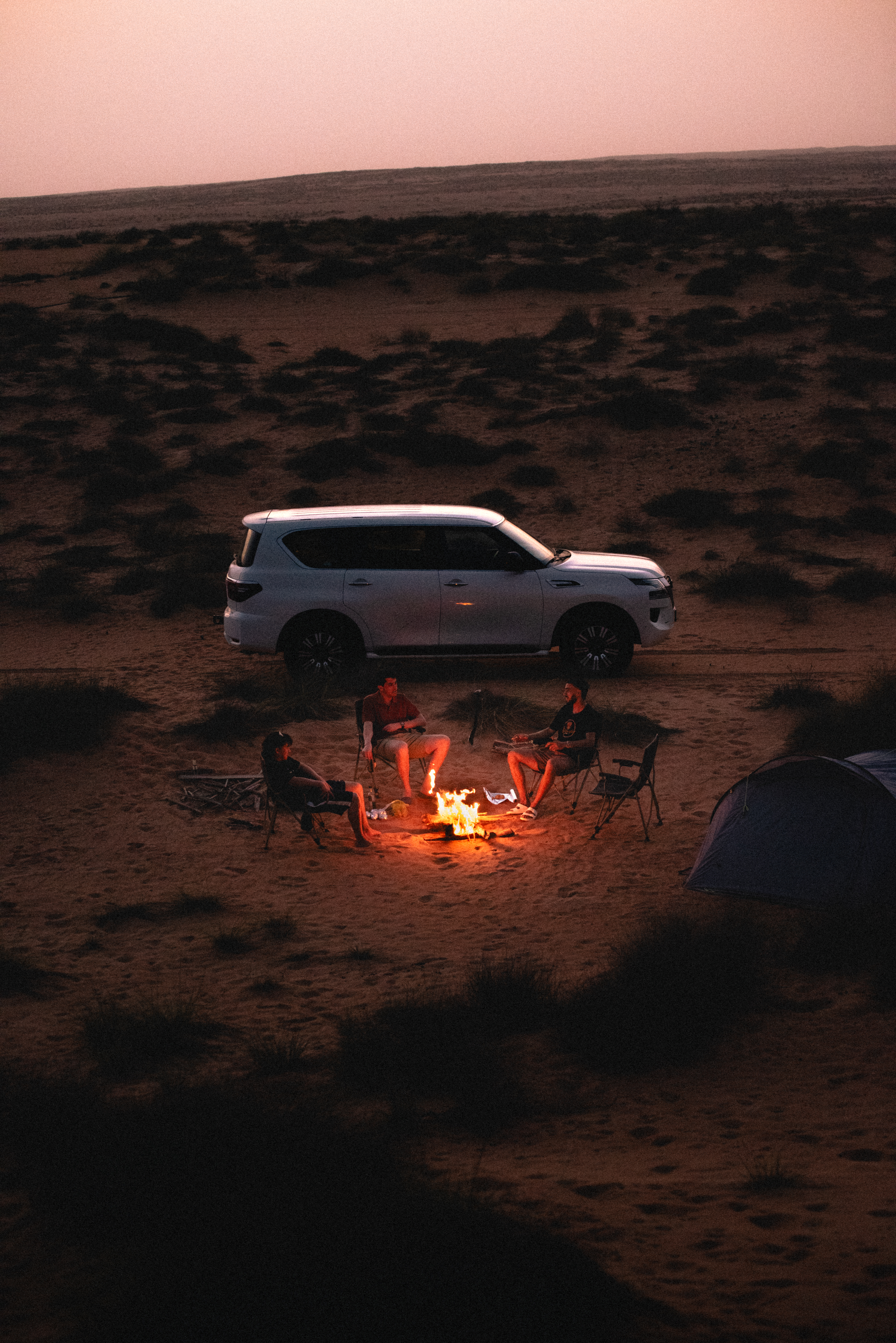 Campfire at the campsite surrounded by dunes